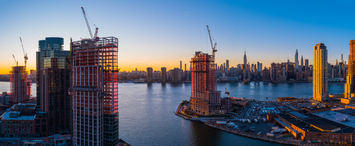 image of city with tall buildings and cranes on top of some buildings